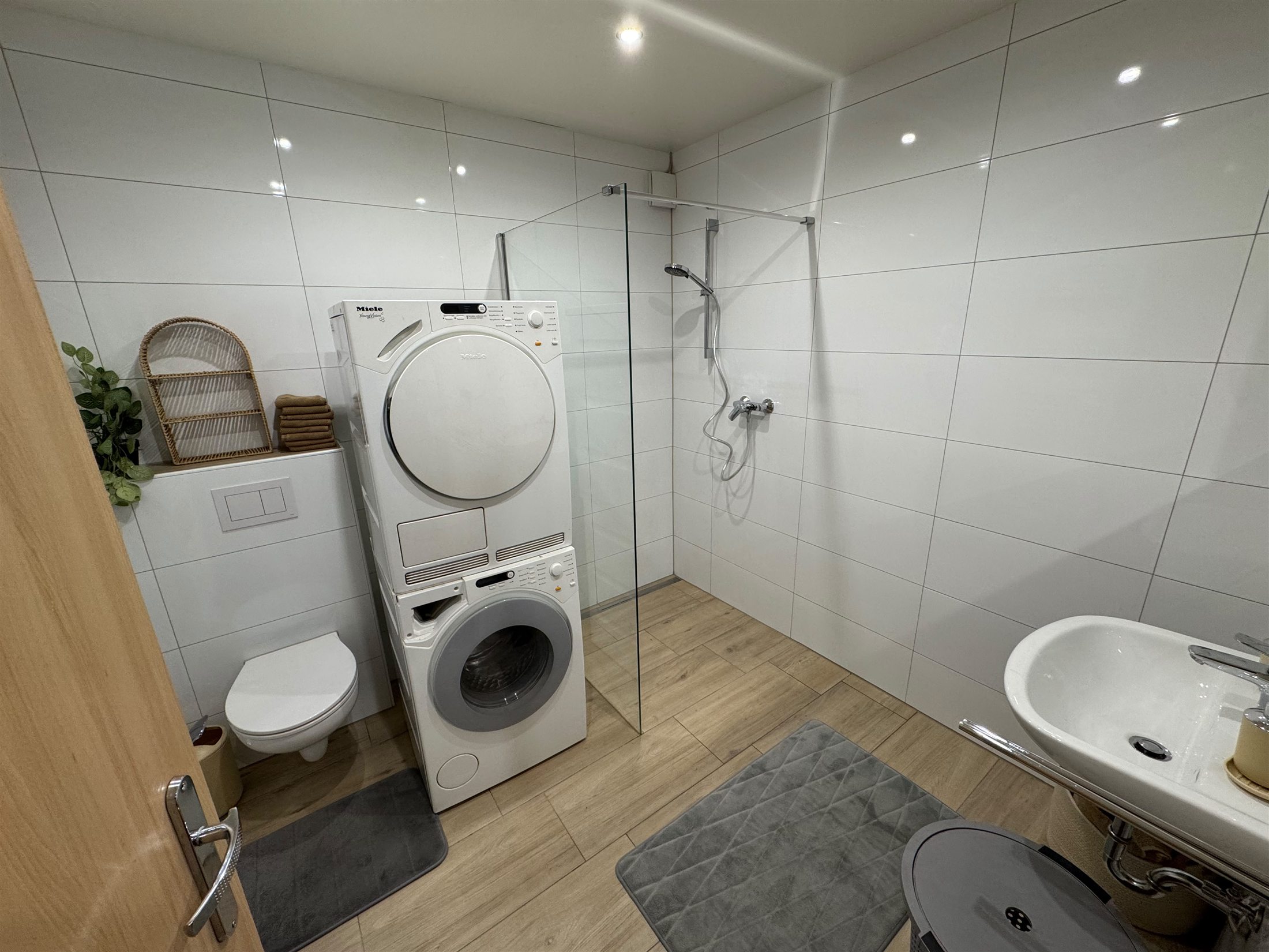 Modernes Badezimmer mit Dusche, Waschmaschine und Trockner